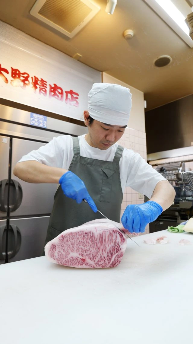 お肉をカットする店主